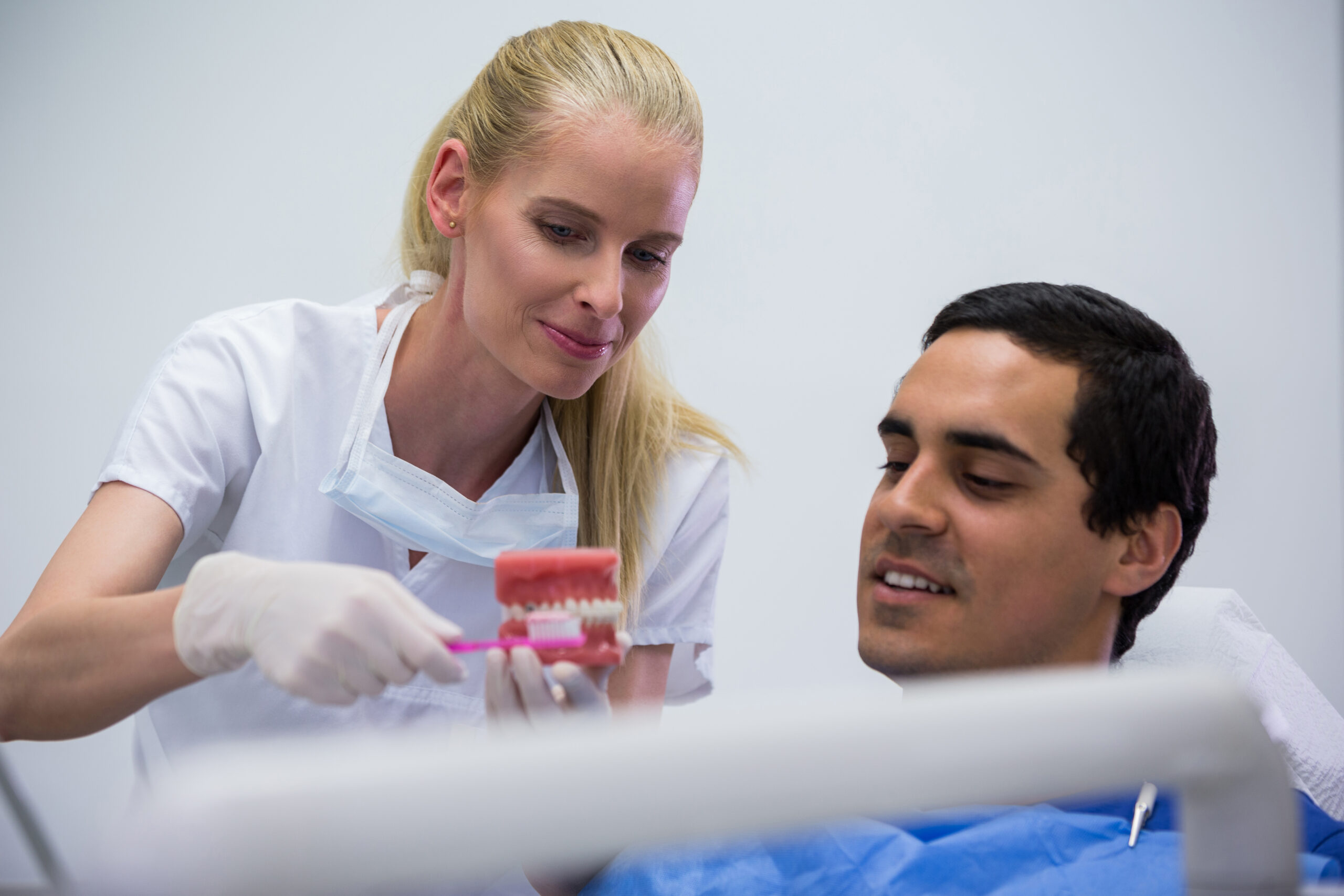 A dentist briefing a patient about the signs you need an expert for All-on-X dental implants Glendale