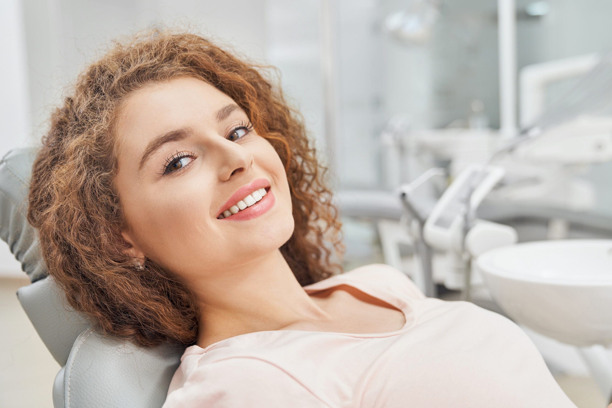 A patient smiling in a dental office for all-on-X dental implants
